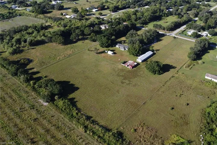 Aerial view of property and surrounding area featuring rural landscape and large plots for crops
