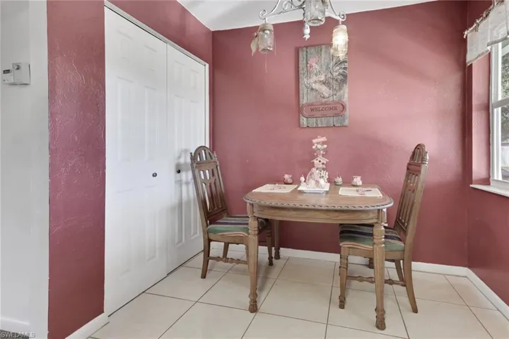 Tiled dining room featuring a chandelier and a textured wall