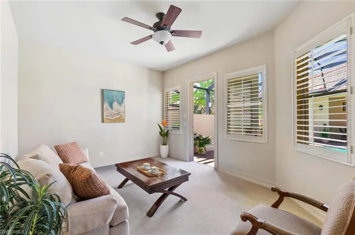Living area with carpet flooring, baseboards, and a ceiling fan