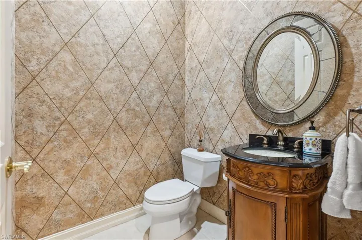 Bathroom featuring toilet, vanity, and baseboards