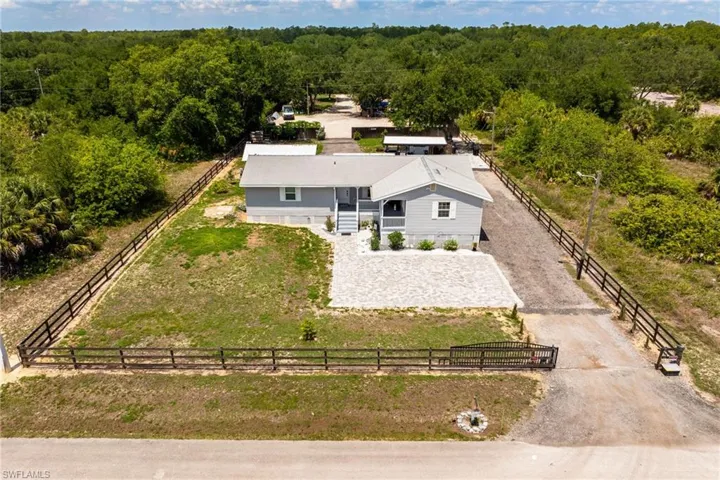 Aerial view of property and surrounding area featuring a forest