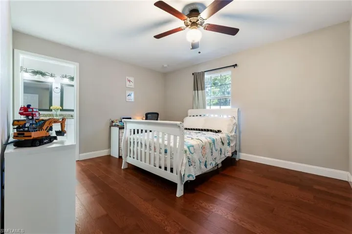 Bedroom with wood finished floors, baseboards, and a ceiling fan