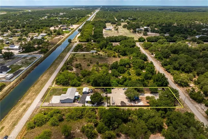 Aerial overview of property's location with a large body of water and property parcel outlined
