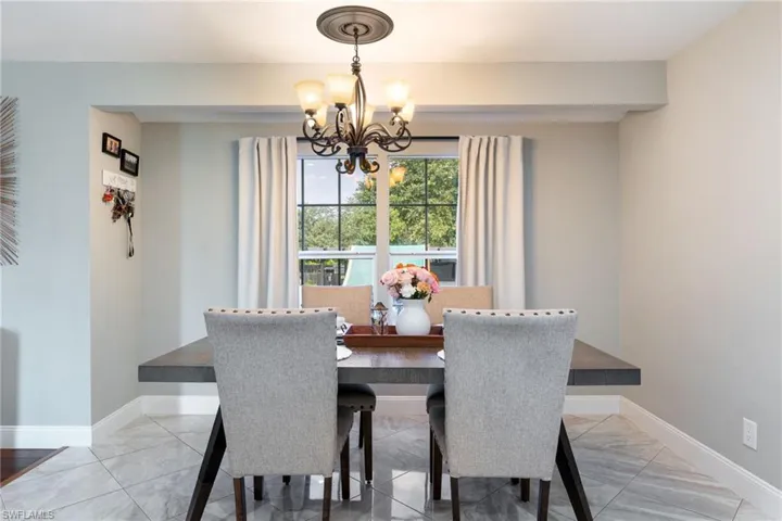 Dining area with a chandelier, baseboards, and light marble finish flooring