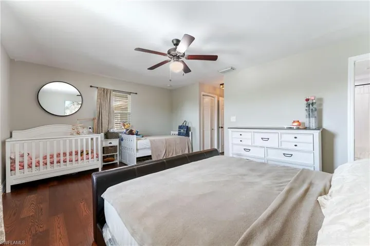 Bedroom featuring dark wood-style floors, ceiling fan, and a closet