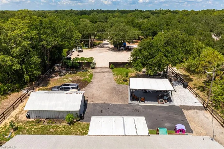 Aerial view of property and surrounding area with a heavily wooded area