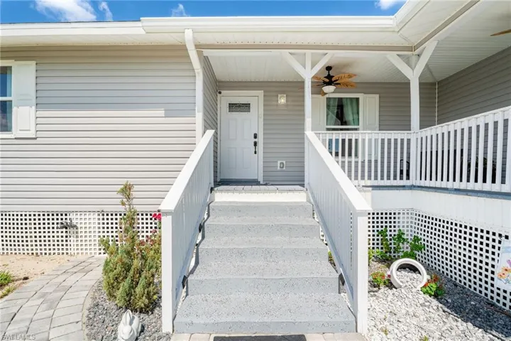 Doorway to property featuring a ceiling fan and covered porch