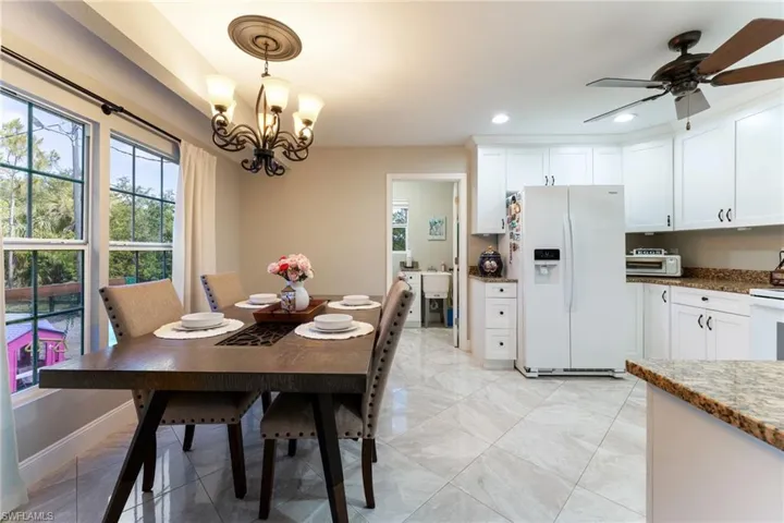 Dining space with recessed lighting, a ceiling fan, a chandelier, and light marble finish flooring