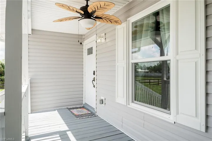 Doorway to property featuring ceiling fan and covered porch