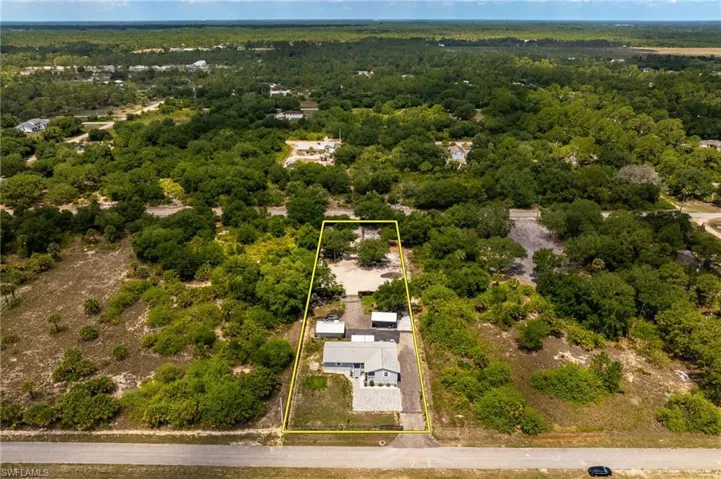 Aerial overview of property's location featuring property parcel outlined and a forest