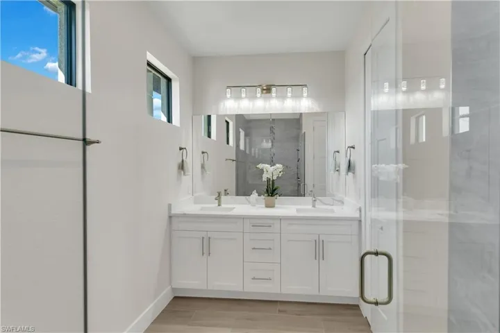 Bathroom with vanity and a shower with door