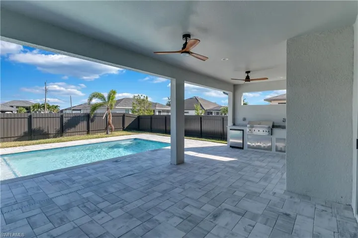 View of pool with area for grilling, a grill, ceiling fan, and a patio