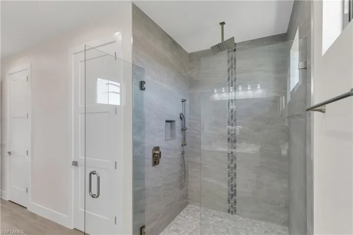 Bathroom with hardwood / wood-style flooring and a shower with door