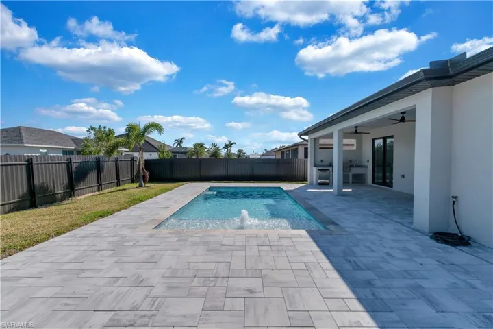 View of pool with ceiling fan, pool water feature, and a patio