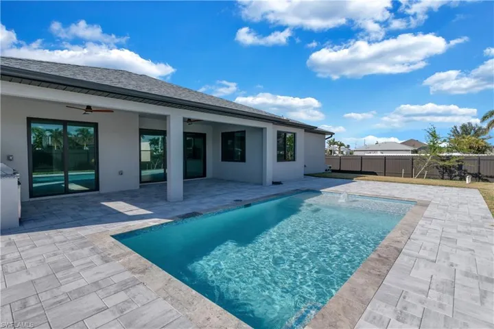 View of pool with a patio, pool water feature, and ceiling fan