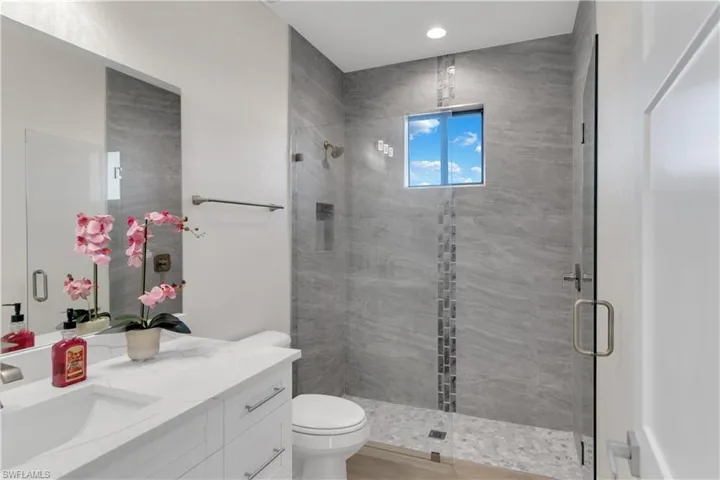 Bathroom with vanity, toilet, and walk in shower