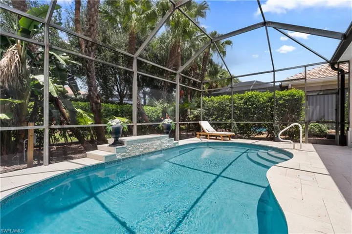 Outdoor pool featuring glass enclosure and a patio