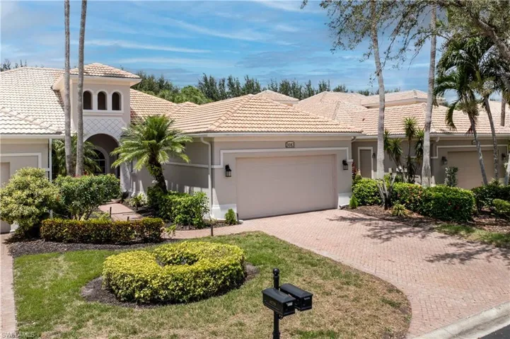 View of front of property featuring an attached garage, decorative driveway, stucco siding, and a tile roof