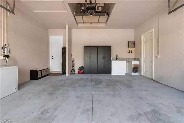 Garage featuring a textured wall and refrigerator