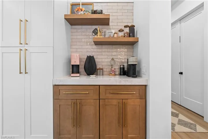 Bar area with decorative backsplash and light wood-style floors