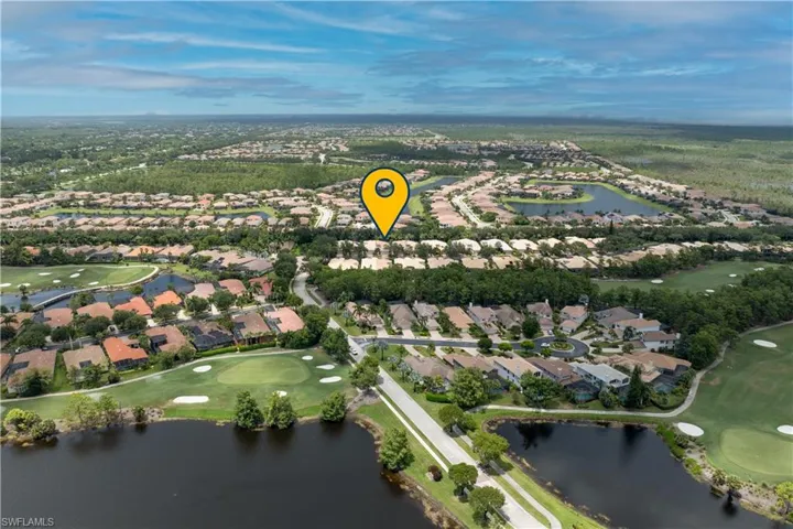 Aerial view of property and surrounding area featuring a golf club and nearby suburban area