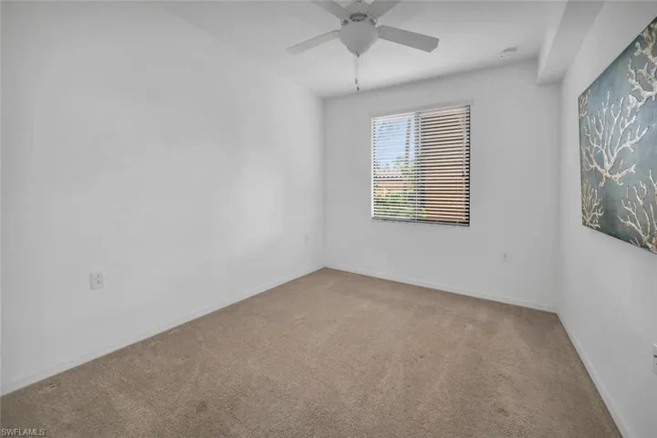 Carpeted empty room featuring ceiling fan