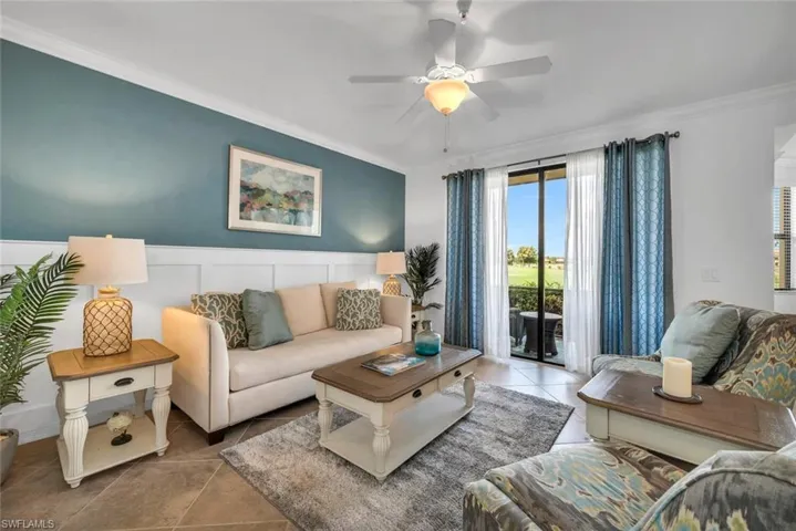 Tiled living room with ornamental molding and ceiling fan