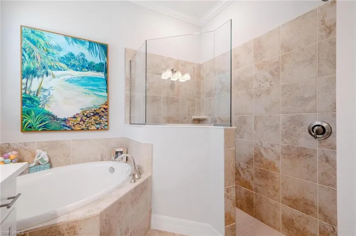 Bathroom featuring crown molding, shower with separate bathtub, and vanity