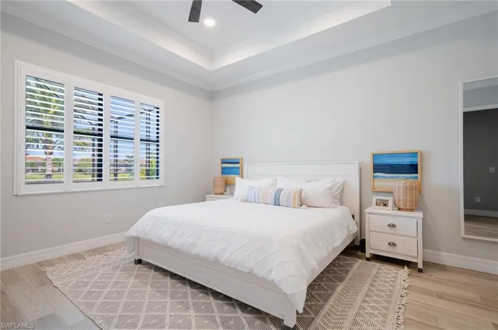 Bedroom with ceiling fan, ornamental molding, and light hardwood / wood-style floors