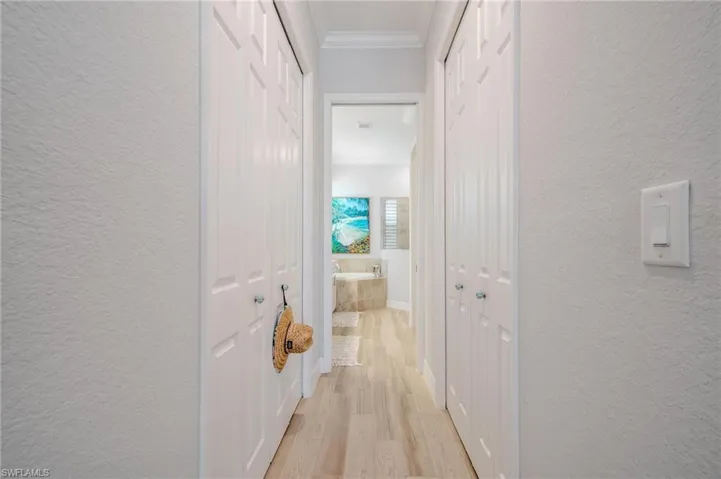 Corridor featuring ornamental molding and light wood-type flooring