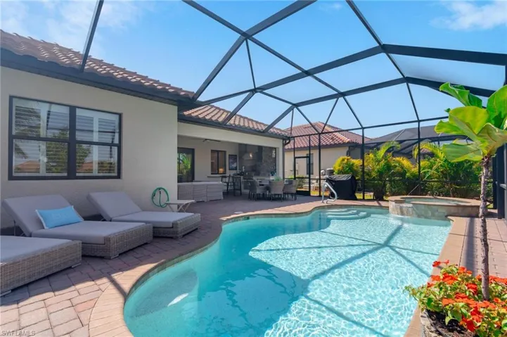 View of swimming pool featuring a lanai, an in ground hot tub, and a patio