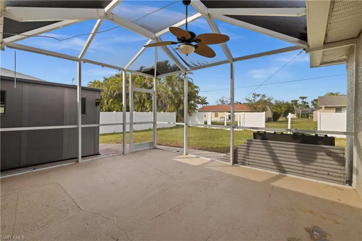Unfurnished sunroom with vaulted ceiling and ceiling fan