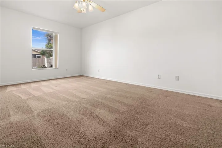 Spare room with light colored carpet and ceiling fan