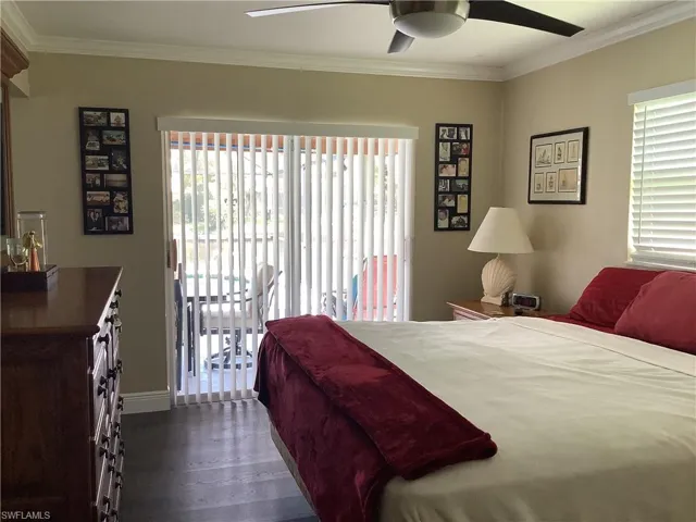 Bedroom with access to outside, ornamental molding, dark wood-style floors, multiple windows, and a ceiling fan