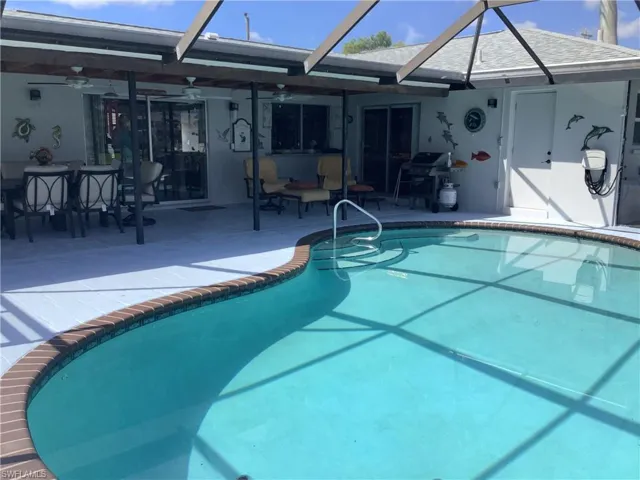 Outdoor pool with glass enclosure, a patio, grilling area, a sunroom, and outdoor dining area