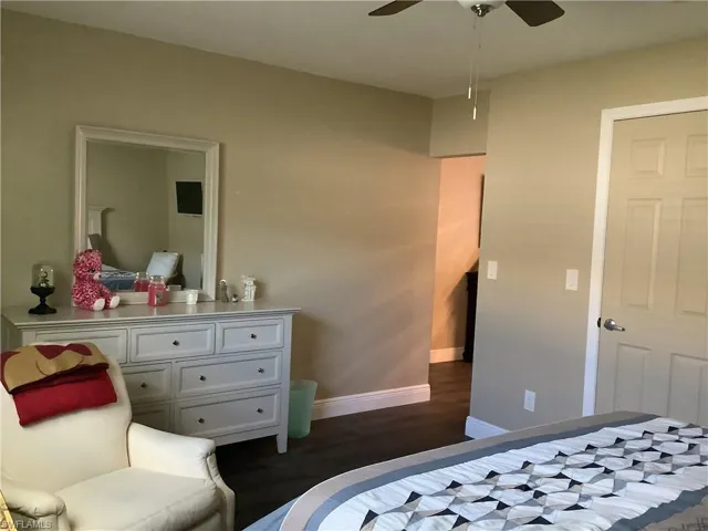 Bedroom with dark wood-type flooring and a ceiling fan