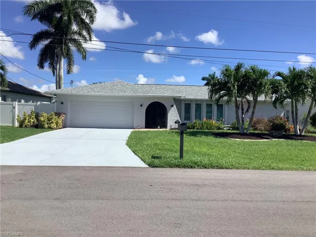 Single story home featuring an attached garage, stucco siding, a front yard, and concrete driveway