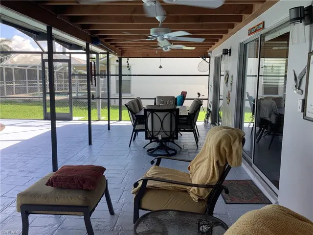 View of patio with a sunroom, a ceiling fan, a lanai, and outdoor dining area
