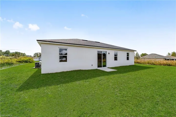 Back of house with a yard