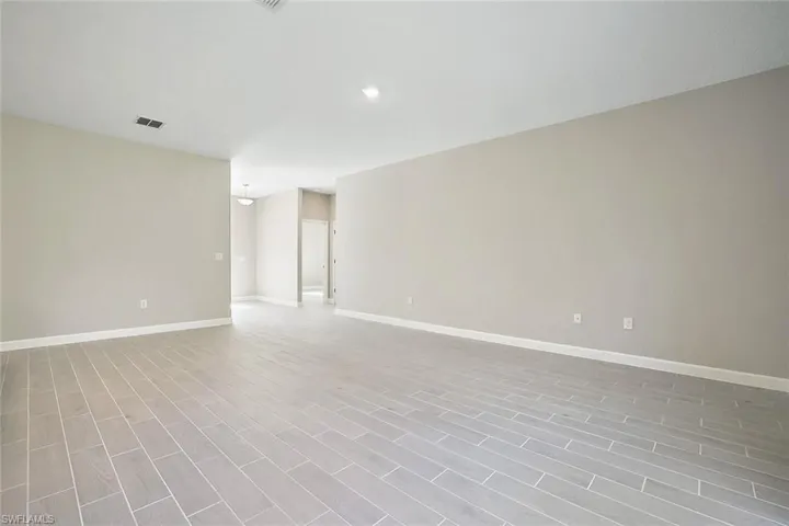 Empty room with light hardwood / wood-style flooring