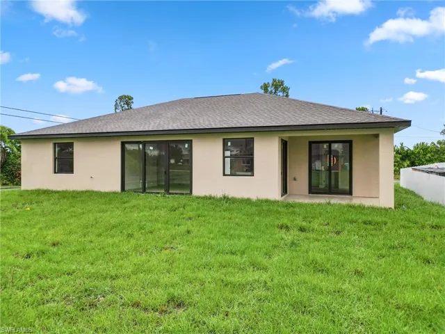 Back of property with a lawn