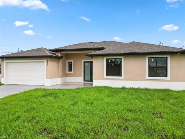 View of front of home featuring a garage and a front lawn