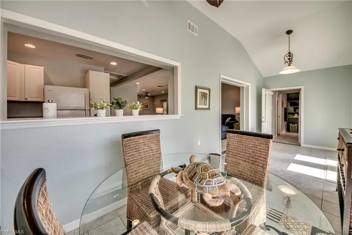 Dining room with tile patterned floors and lofted ceiling