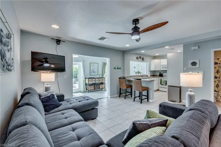 Living area featuring ceiling fan, recessed lighting, light tile patterned floors, and a textured ceiling