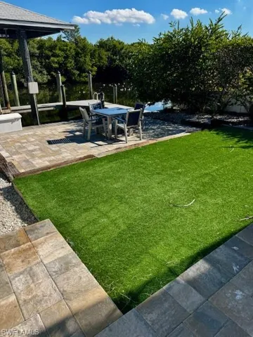 View of grassy yard with a patio area