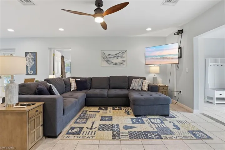 Living room featuring recessed lighting, light tile patterned floors, and a ceiling fan