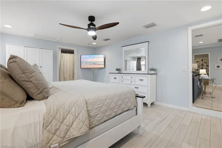 Bedroom featuring attic access, wood finish floors, a closet, ceiling fan, and recessed lighting