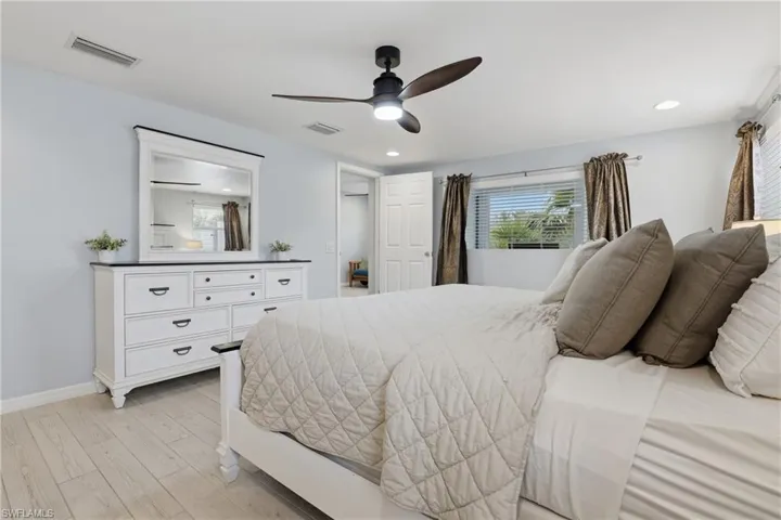 Bedroom with light wood-style floors, a ceiling fan, and recessed lighting