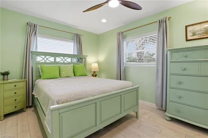 Bedroom with light wood-type flooring, ceiling fan, and recessed lighting