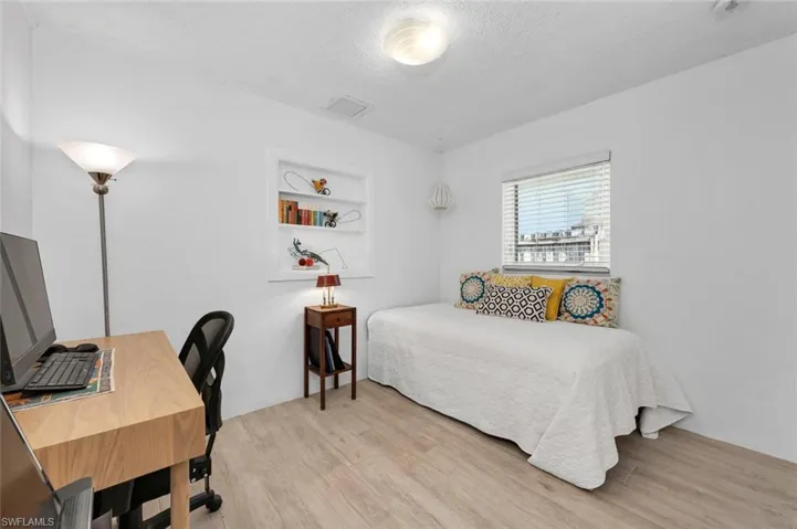 Bedroom featuring light wood-style tile floors and a textured ceiling